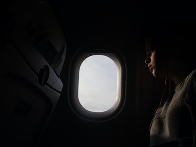 女人骑乘飞机时使用红色式耳机
